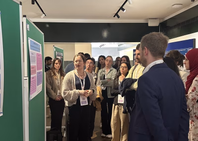 Photo ofa person presenting an abstract in front of exhibition stands